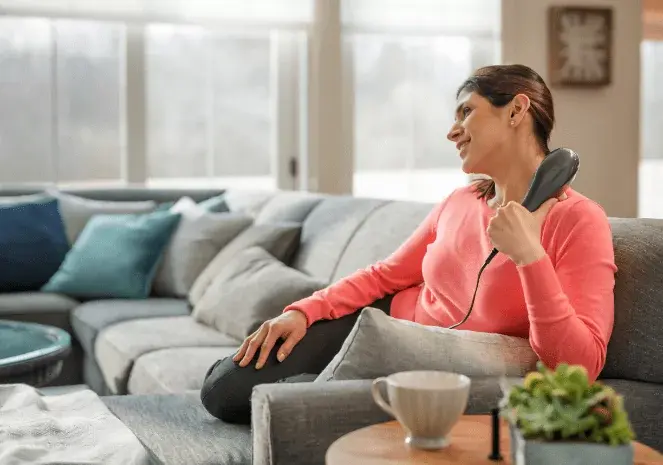 A woman using Wahl deep tissue massager.